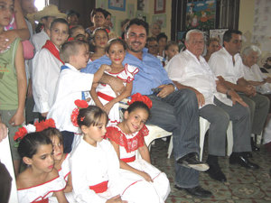  Moisés Plasencia rodeado de niños con el traje típico en su reciente visita a Cuba.