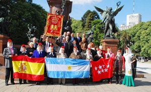  Directivos, autoridades consulares y la reina de la Casa regional posan ante el monumento al General San Martín. 