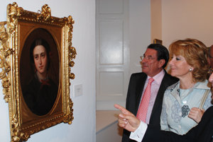  La presidenta de la Comunidad de Madrid, acompañada por Francisco Vázquez, observa uno de los cuadros expuestos.