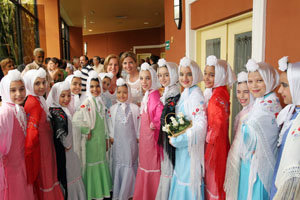   Victoria Cristóbal posa con las niñas que lucen los vestidos llevados desde Madrid.