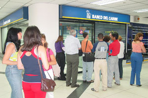 Unas personas ante la sucursal del Banco del Caribe, en el sótano de la HGV, tras el asalto perpetrado en marzo de 2005.